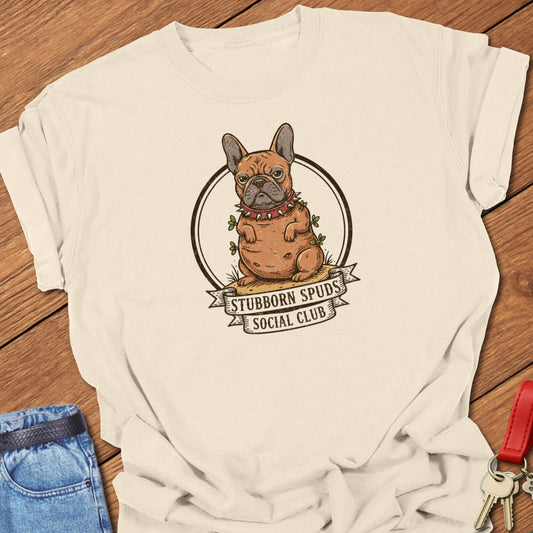 French bulldog illustrated as a potato mascot with “Stubborn Spuds Social Club” banner design printed on ivory Comfort Colors t shirt.